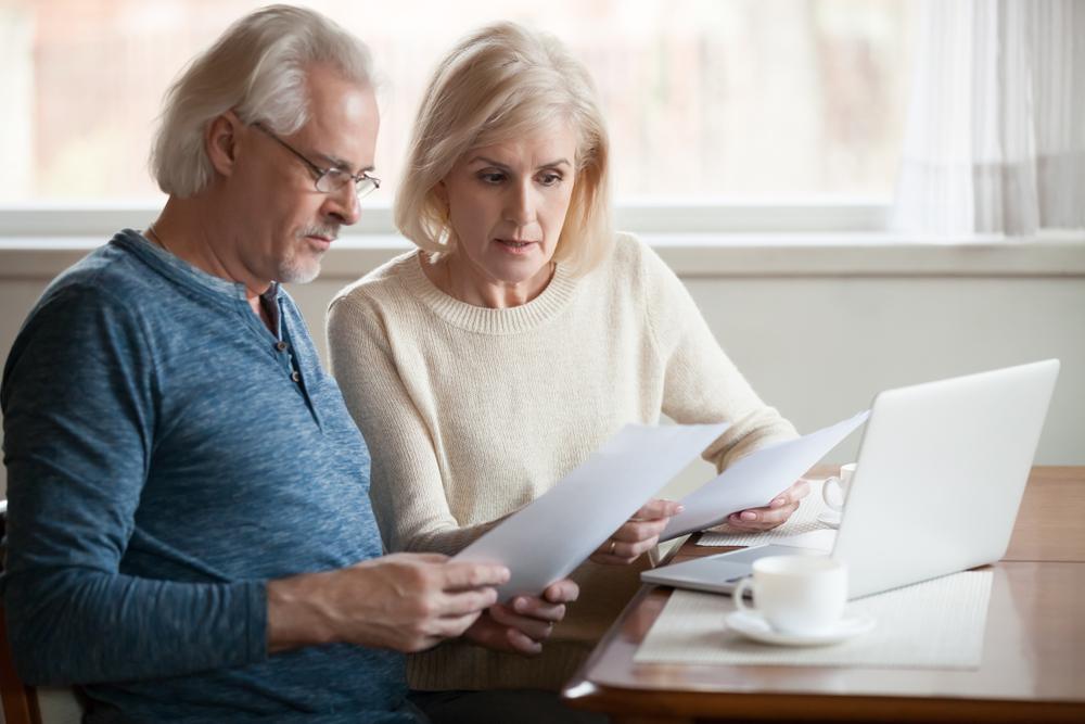 An older couple reviews documents and discusses whether you need a lawyer to become the executor of an estate. 